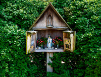 Roadside Shrine with Religious Figurines and Flowers