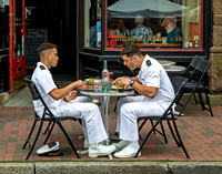 Military men eating lunch at an outdoor cafe.
