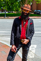 Smiling Man with Beard and Hat on Sidewalk