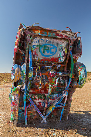 Colorful spray-painted vehicle in an art installation.