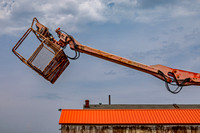 Rusty Boom Lift Bucket Above Building