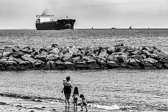 Family Watches Ship Pass By on Water