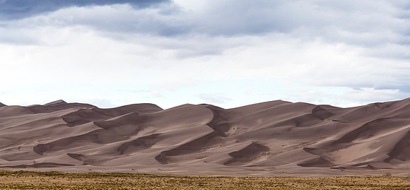 Dramatic Sand Dunes Under Cloudy Sky