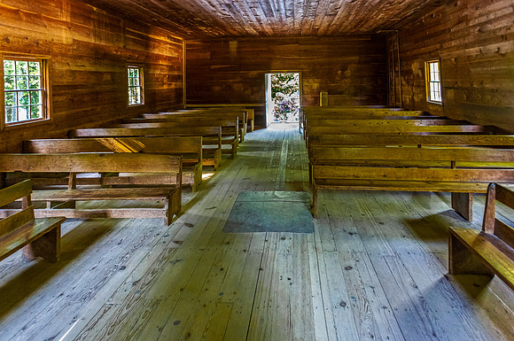 Old Wooden Church Interior with Sunlight and Pews