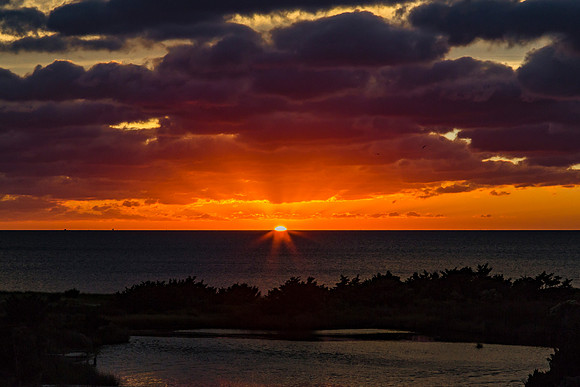 Dramatic Sunset Over Ocean and Landscape