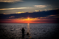 Woman and Dog in Water at Sunset
