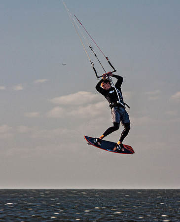 Kiteboarder performs aerial jump over ocean