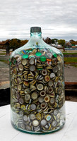 Glass Jug Full of Bottle Caps