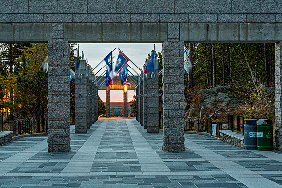 Pathway with Pillars and Flags at Sunrise