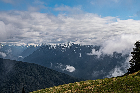 Cloudy Mountain Range with Snow-Capped Peaks