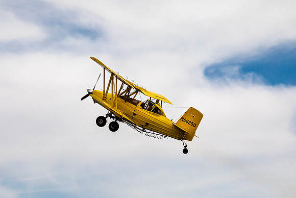 Yellow Crop Duster Biplane in Flight