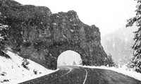 Winter Road Through Rock Tunnel in Snowfall