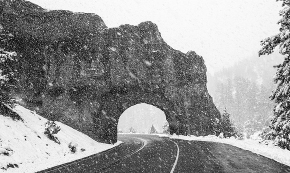 Winter Road Through Rock Tunnel in Snowfall