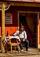 Man in Western Attire on Rustic Porch