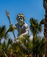 King Neptune Statue Among Palm Trees