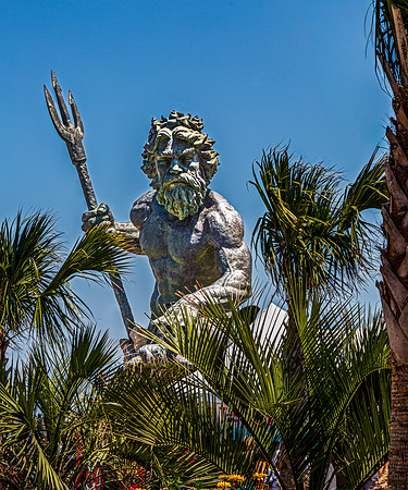 King Neptune Statue Among Palm Trees