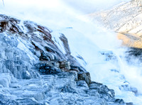 Steaming Waterfall with Ice Formations in Mountains