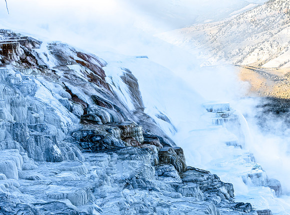 Steaming Waterfall with Ice Formations in Mountains