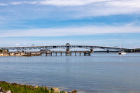Bridge, Beach, and Sailboat on Water